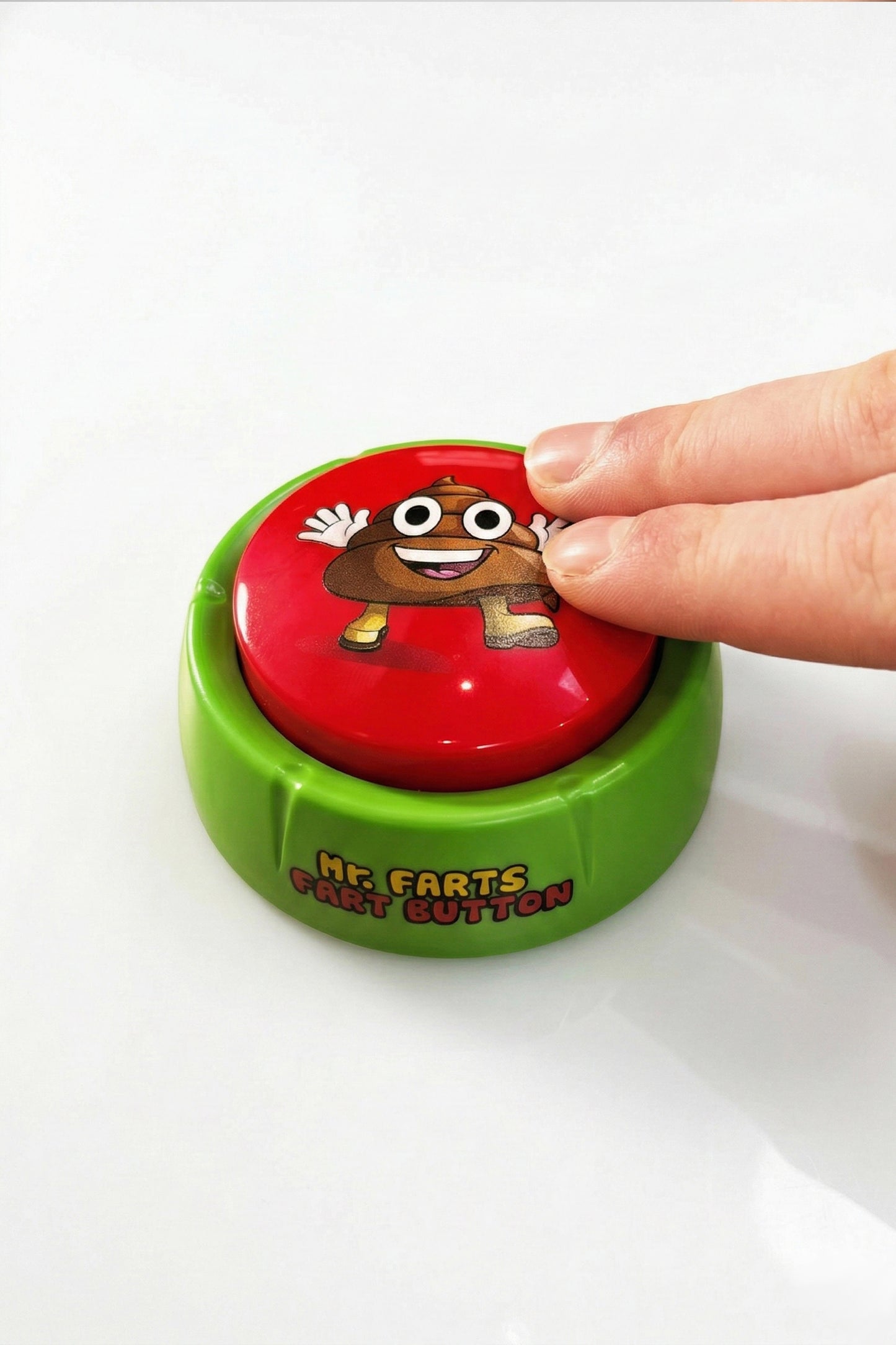 mr farts fart button with big red button, being pressed down by 2 fingers on a white background 